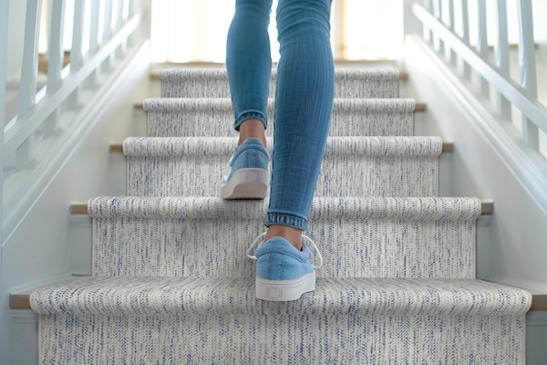 Person walking up carpet stair runner
